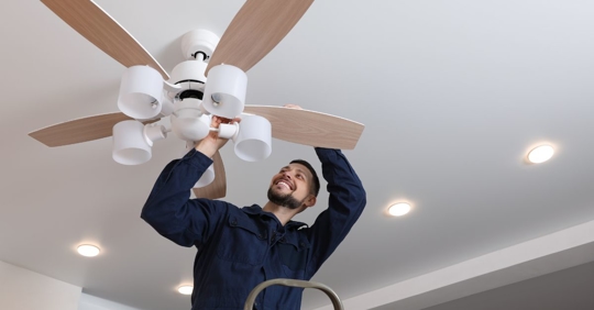 Electrician with tool belt holding electrical wires.